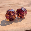 Round earrings with a marbled design on a wooden surface