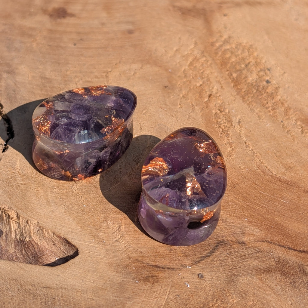 Two purple crystal stones on a wooden surface