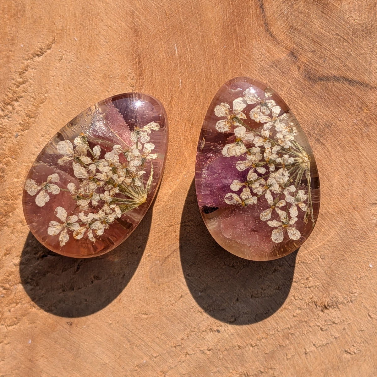 Close up of white dried flowers and black tourmaline preserved in resin EL-Creations