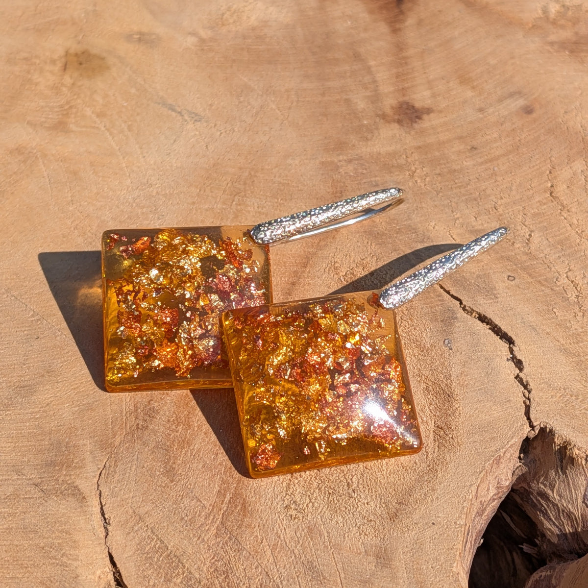 Amber resin square earrings 2cm pendant on wooden surface, unique statement jewelry EL Creations