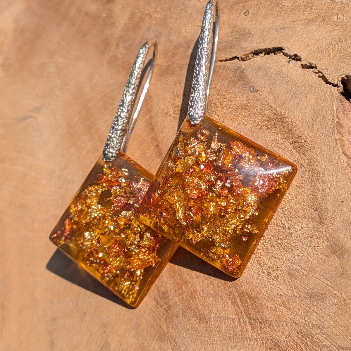 Close-up of gold and copper flakes inside amber resin square earrings, EL Creations Belgium