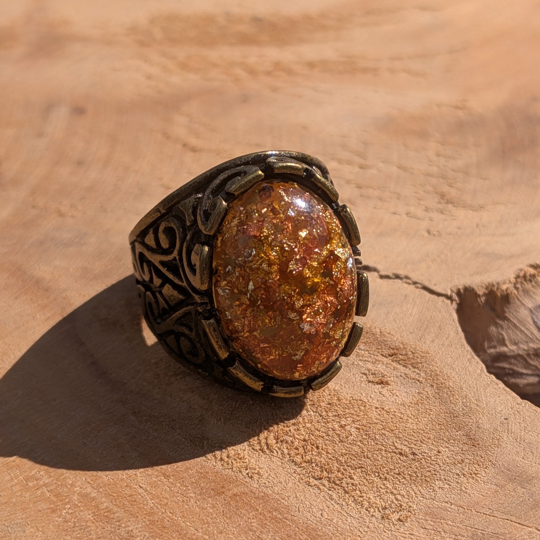 Amber resin ring antique silver filigree scrollwork side view on stone in sunlight – EL-Creations