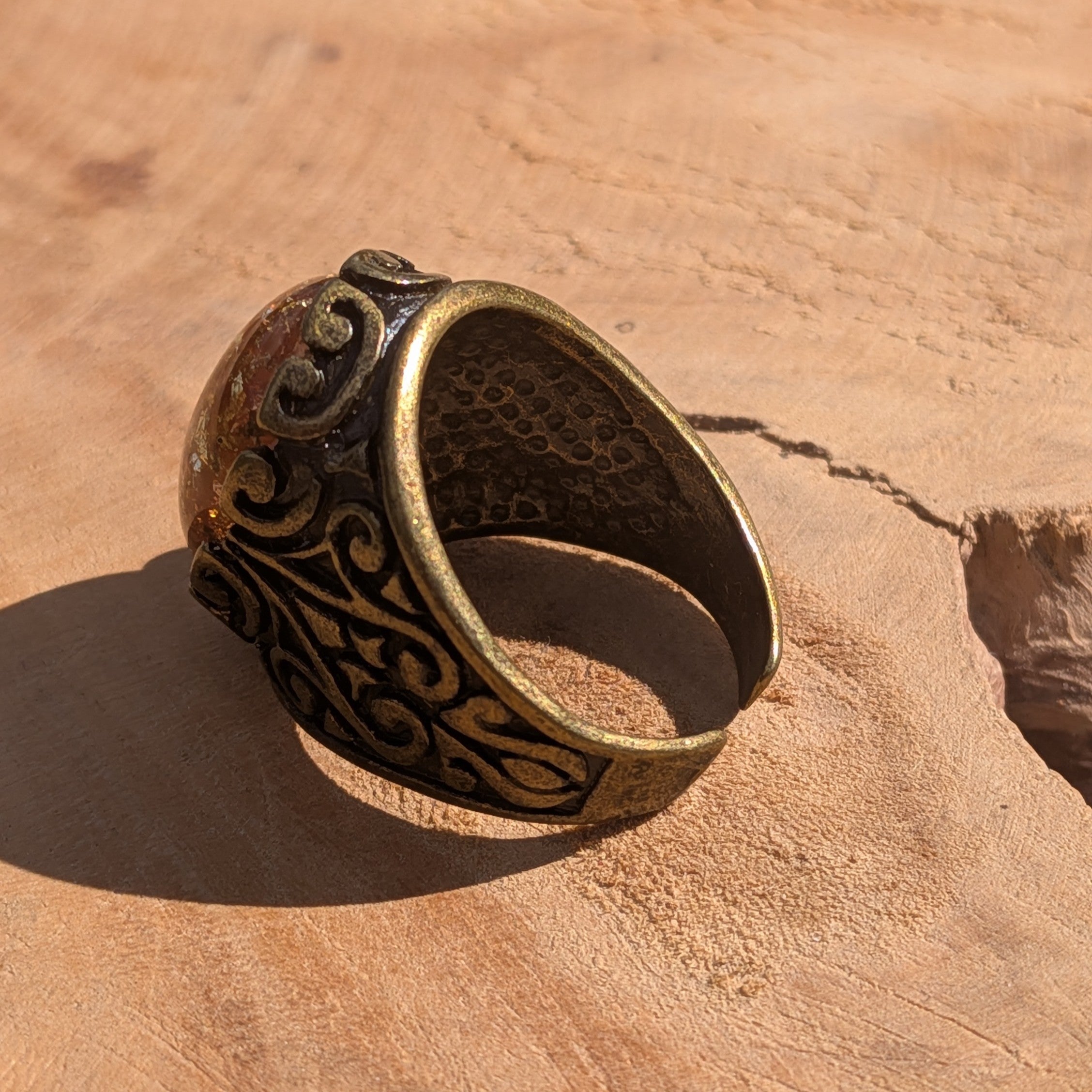 Amber resin ring antique silver filigree base copper gold flakes front view on stone – EL-Creations