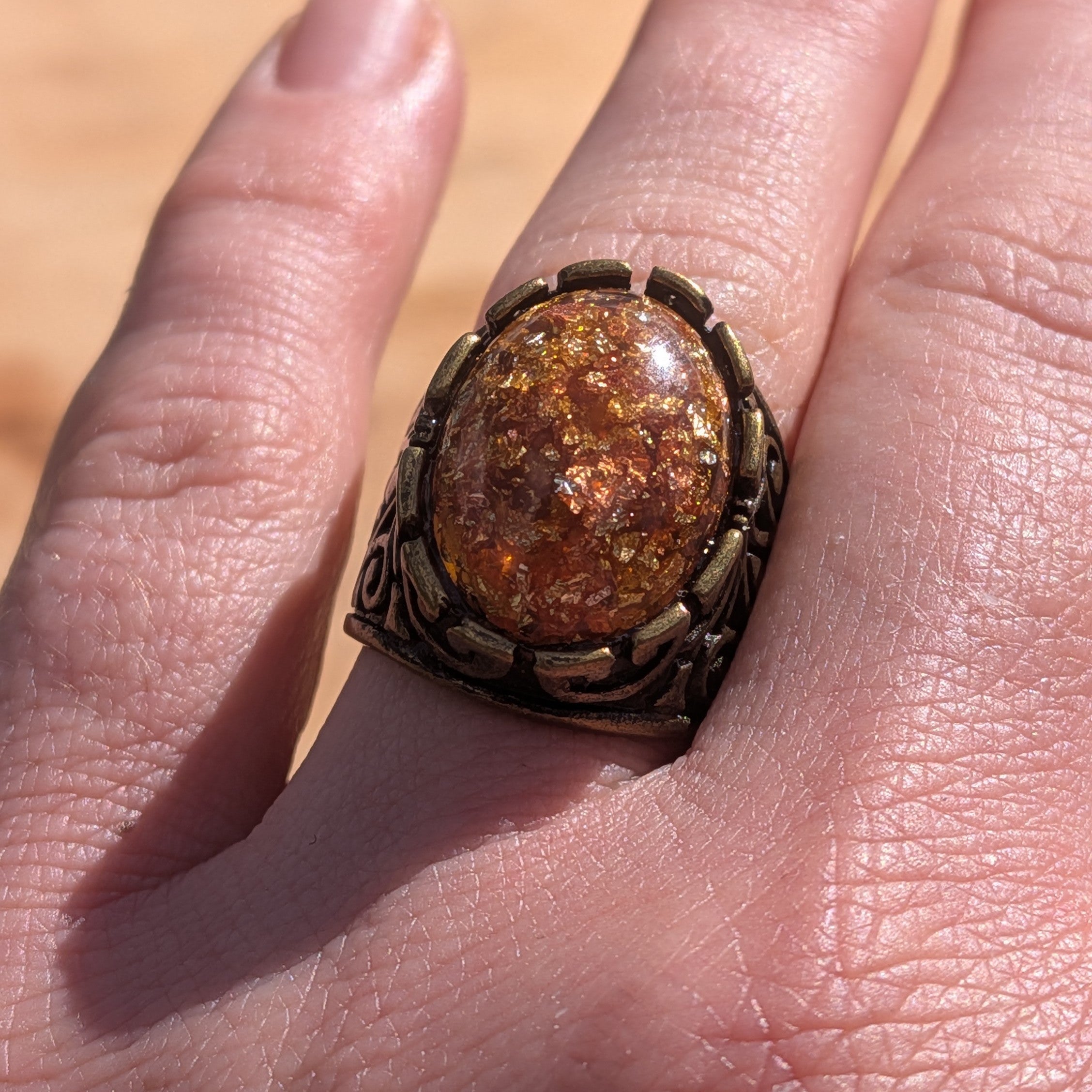 Amber resin ring antique silver scrollwork band worn on finger top view – EL-Creations