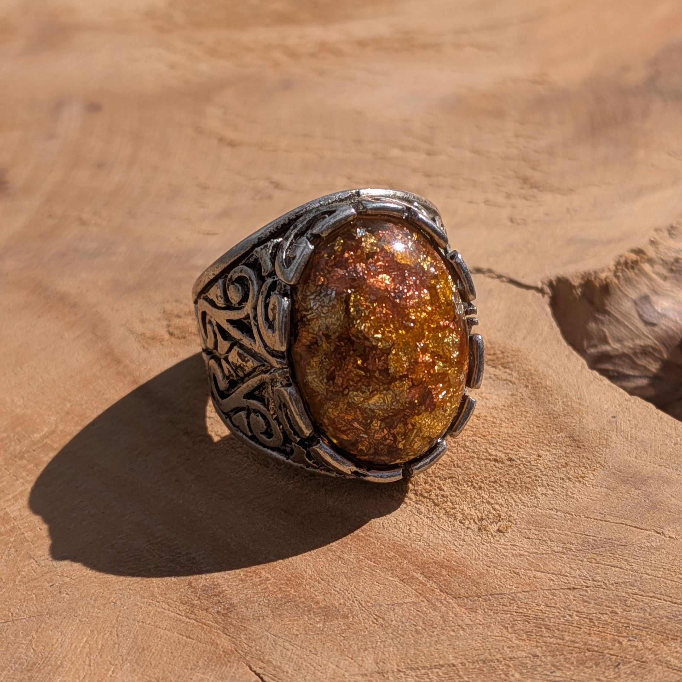 Amber resin ring antique bronze filigree scrollwork side view on stone in sunlight – EL-Creations