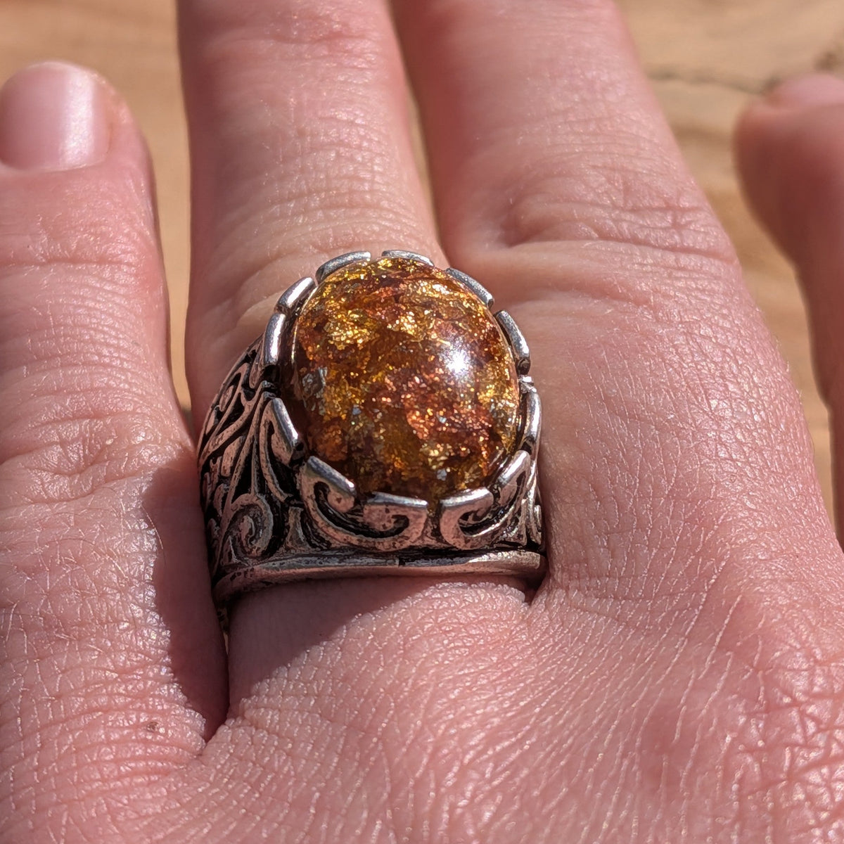 Amber resin ring antique bronze scrollwork band worn on finger side view – EL-Creations