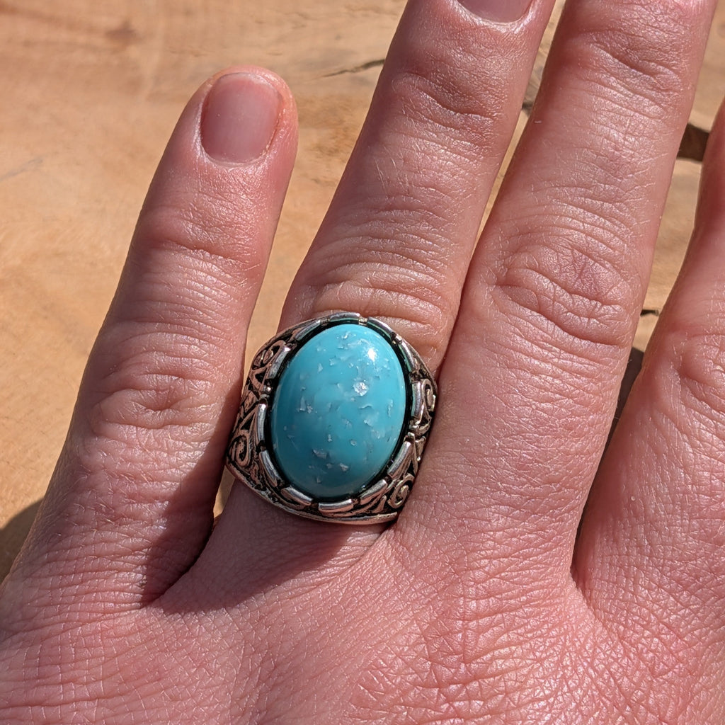 Turquoise resin ring antique silver scrollwork band diagonal view on finger warm light – EL-Creations
