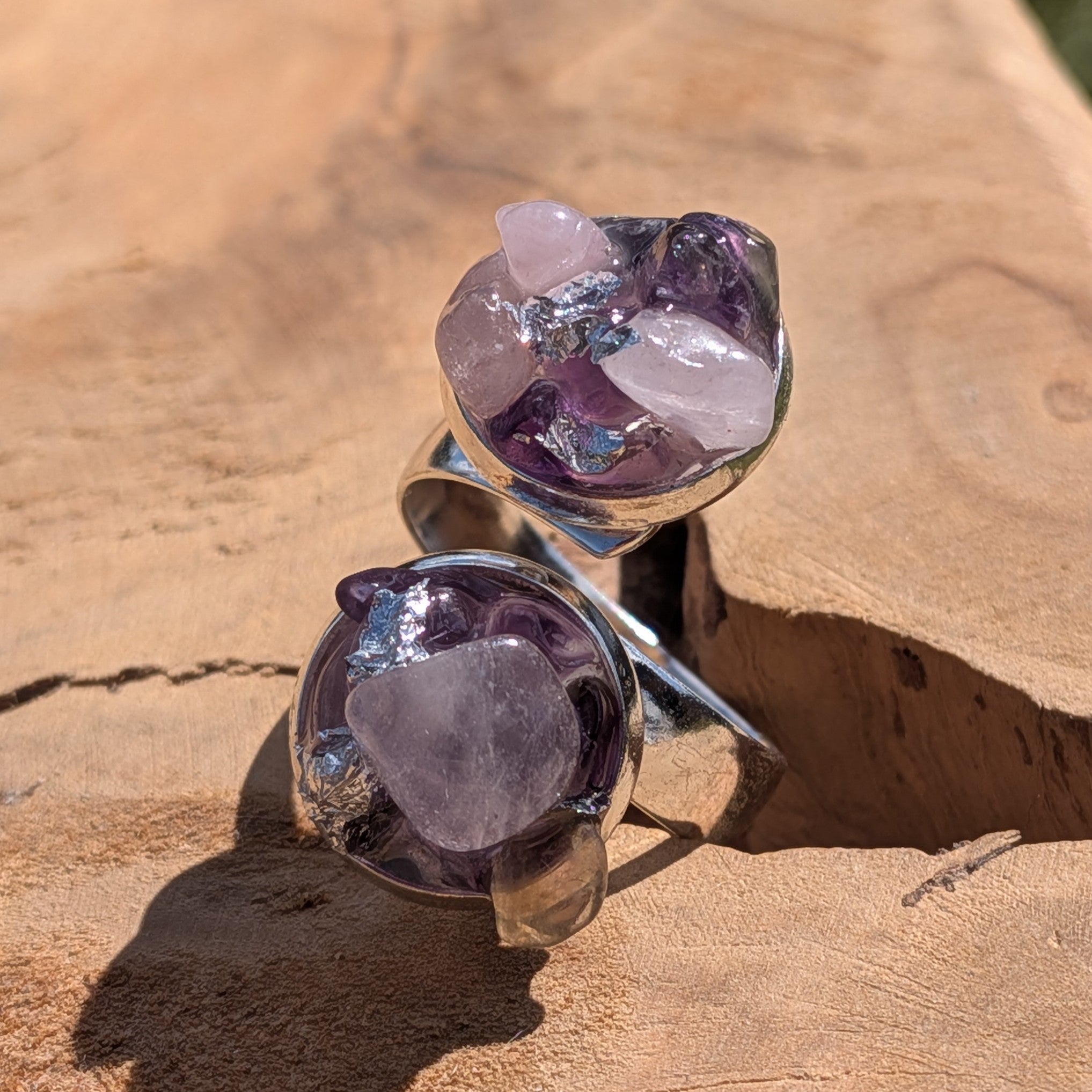 Amethyst rose quartz bypass ring on wood, close-up of two open silver settings with raw crystal clusters – EL-Creations