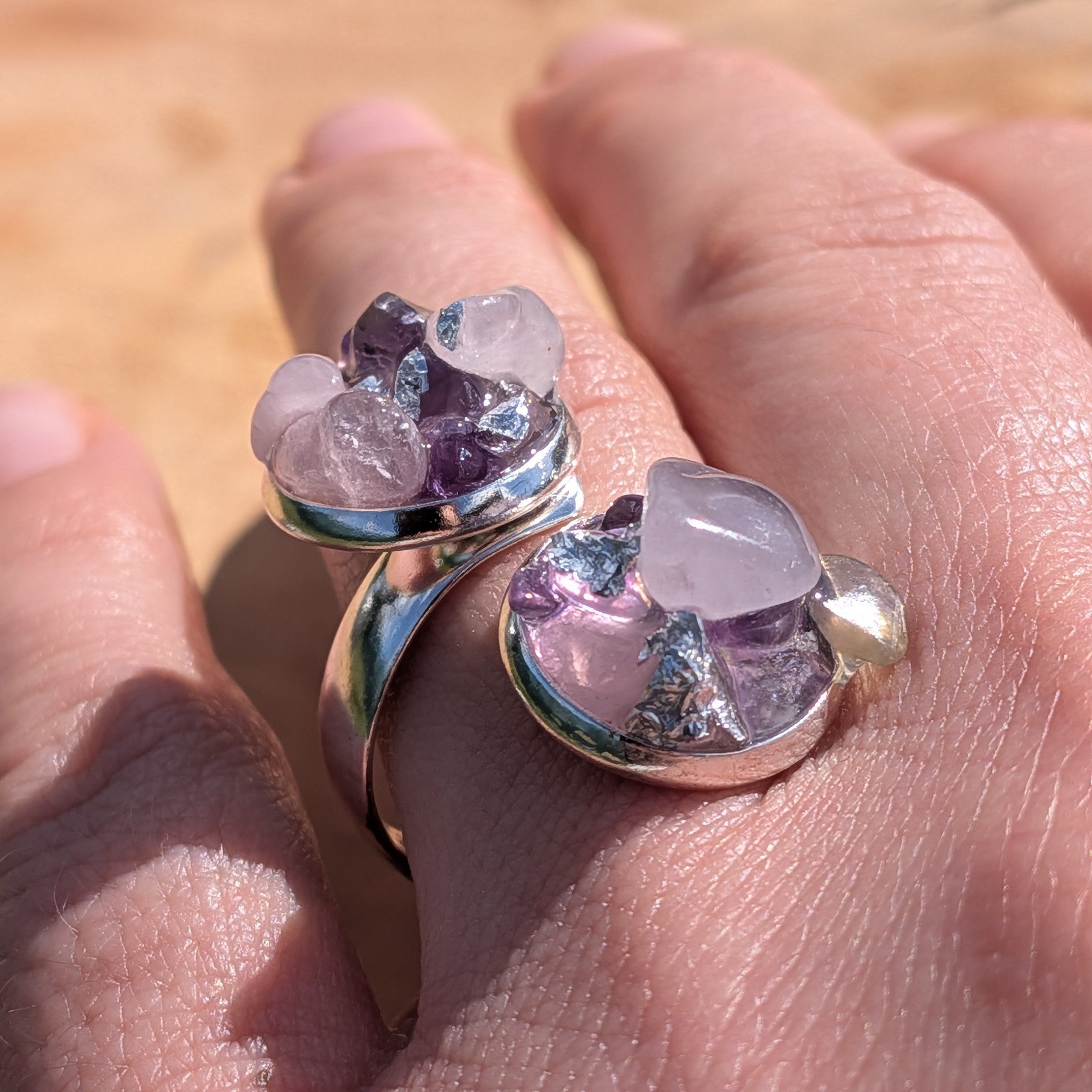 Raw amethyst rose quartz bypass ring on fingers, top view of two open silver settings with crystal clusters – EL-Creations
