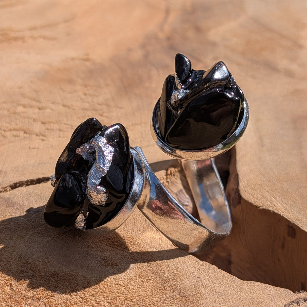 Two raw black obsidian rings held on fingers, top view, silver jewellery alloy base – EL-Creations