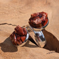 Two red jasper double stone cluster rings on sandy rock surface, raw stone fragments in silver alloy settings – EL-Creations