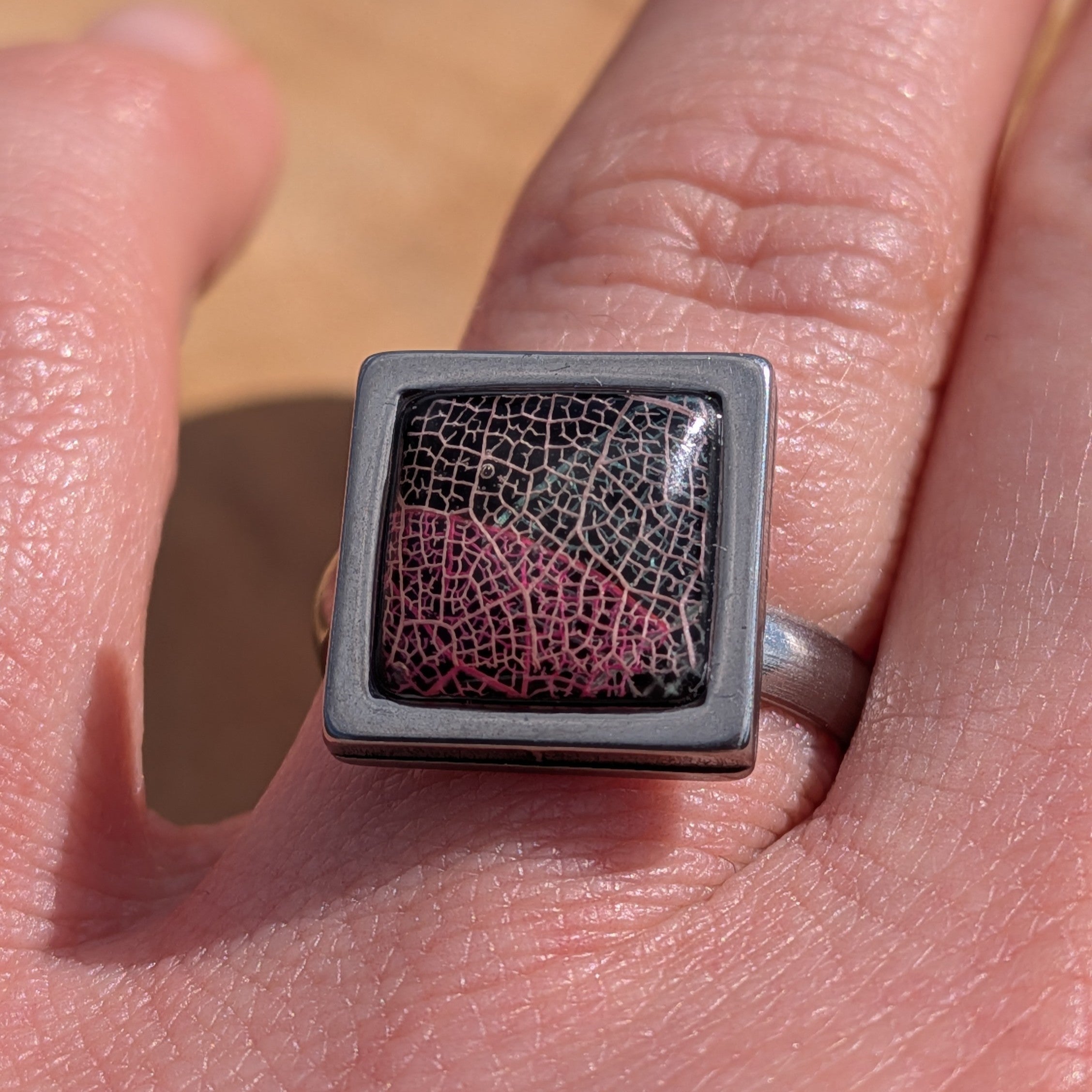 Top view of black and burgundy skeleton leaf resin ring, 14×14mm square gunmetal stainless steel bezel – EL-Creations