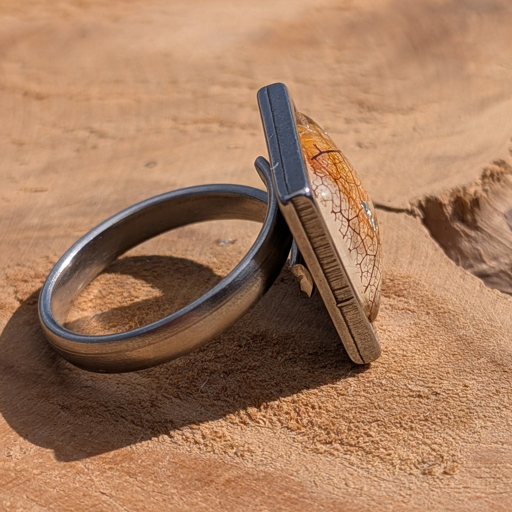 Front view of skeleton leaf resin ring on wood, 15×15mm square gunmetal stainless steel bezel – EL-Creations