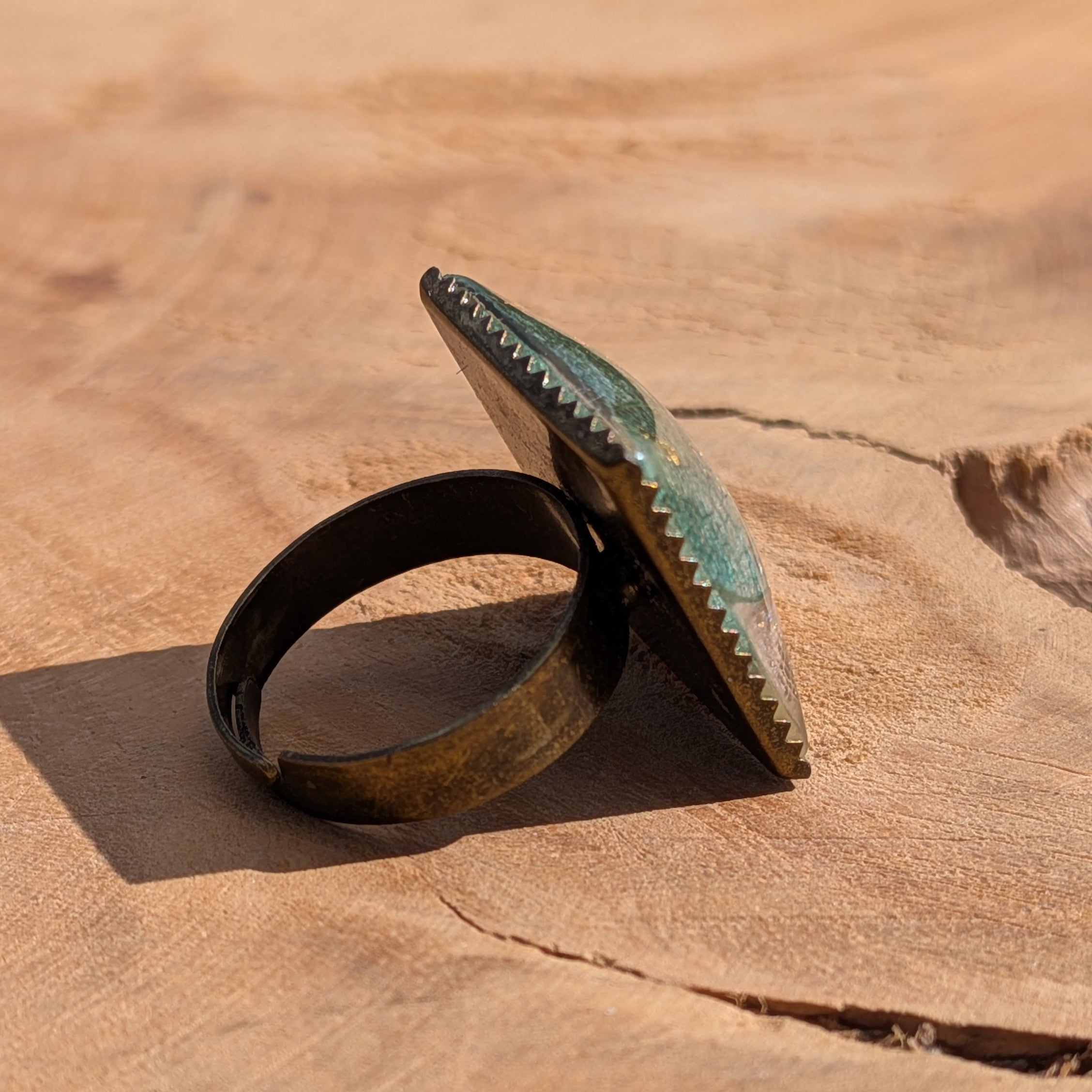 Skeleton leaf resin ring worn on finger, close-up of 20mm square antique bronze bezel with copper gold flakes – EL-Creations