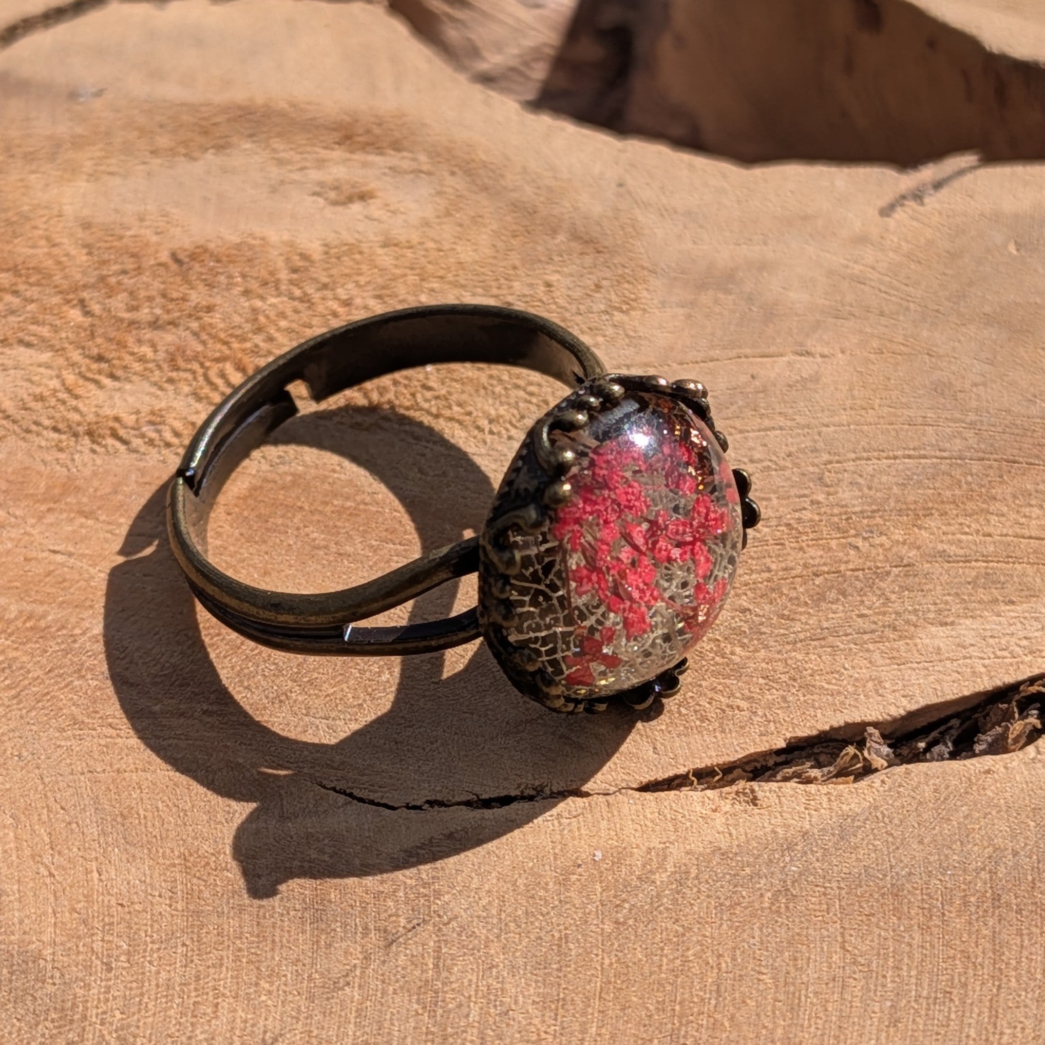Red Queen Anne's Lace resin ring worn on finger, close-up of dried flowers and skeleton leaf in bronze crown – EL-Creations