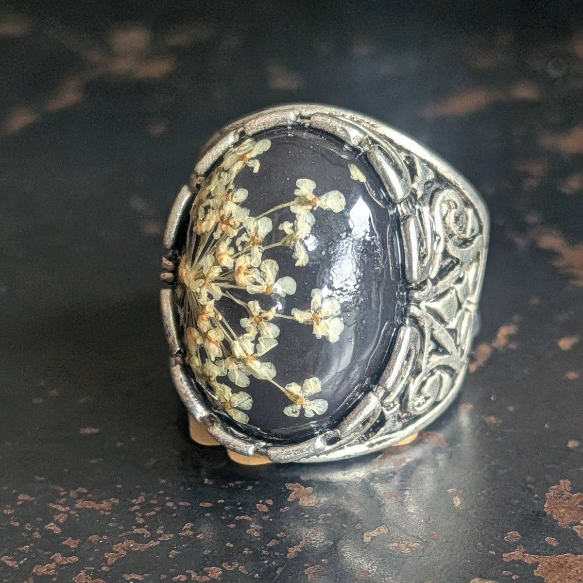 Handmade botanical resin ring with real Queen Anne's Lace flowers in black oval cabochon worn on fingers – EL-Creations