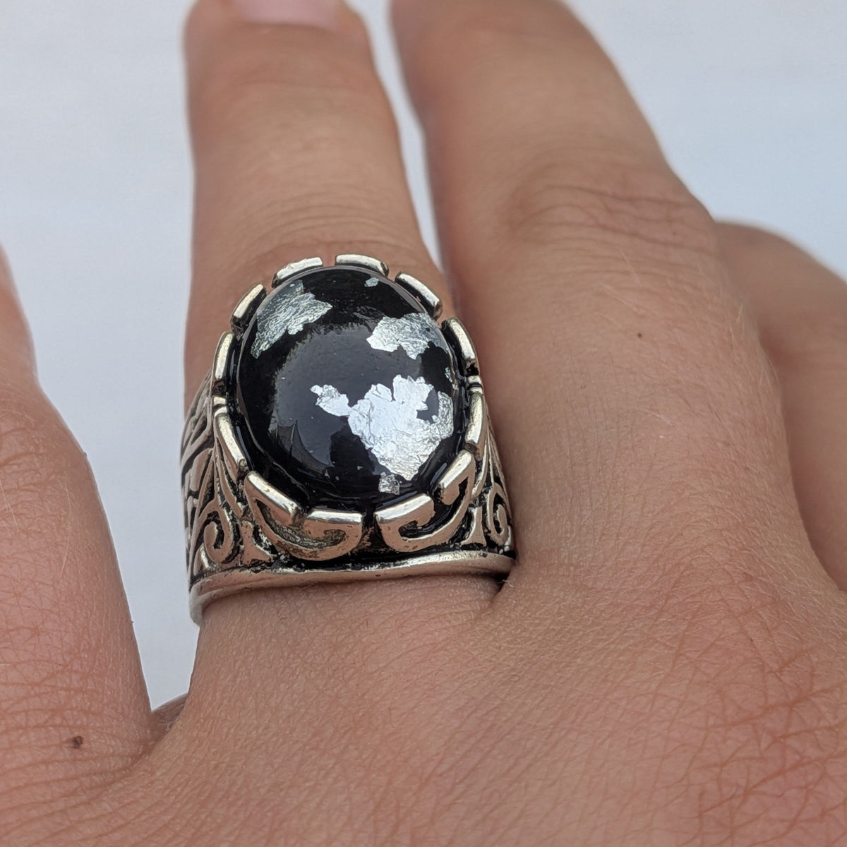 Handmade black resin ring with silver flakes 18x15mm oval cabochon front view on wooden surface – EL-Creations