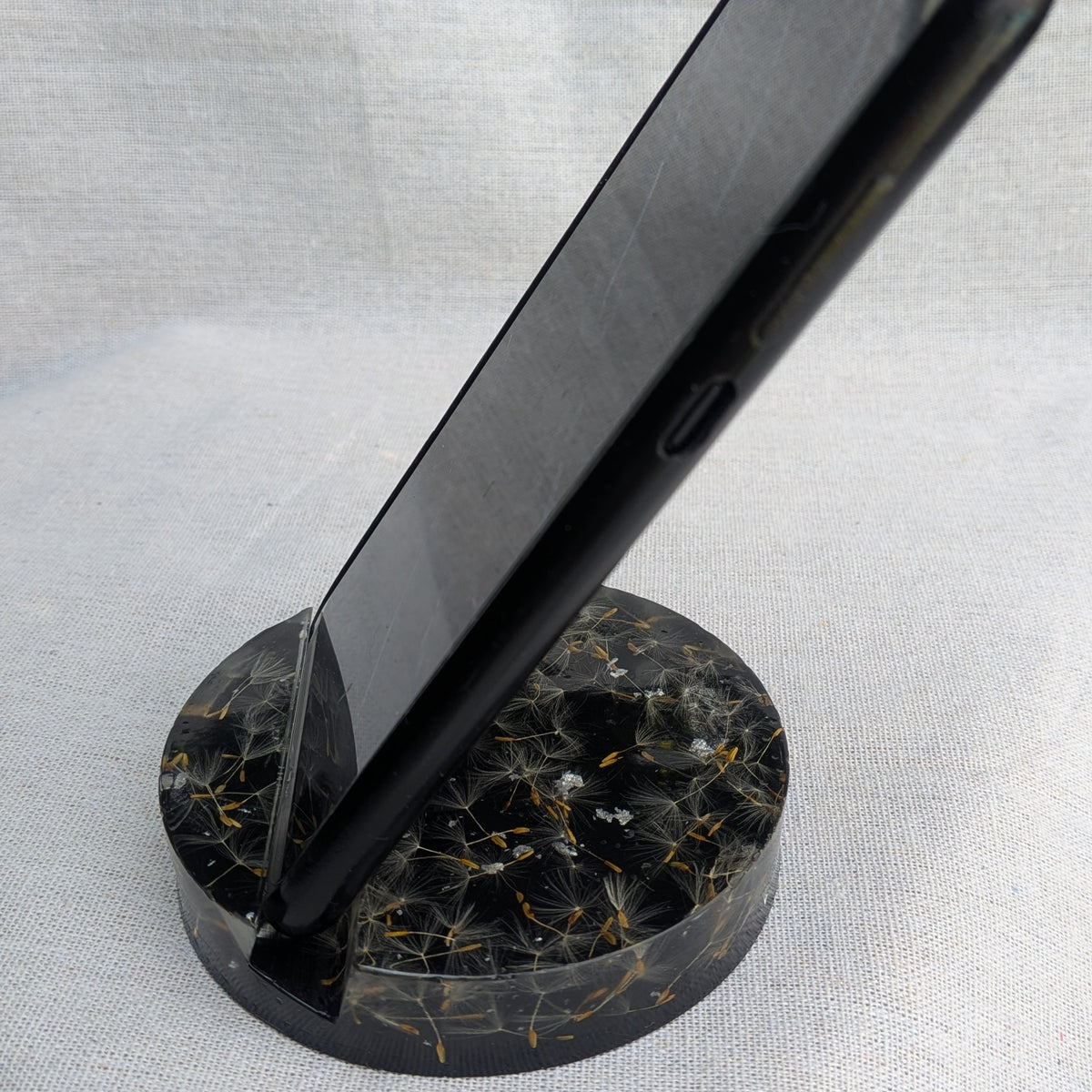 Top view of black resin phone holder with dandelion seeds and silver flakes – unique handmade gift – EL-CreationS