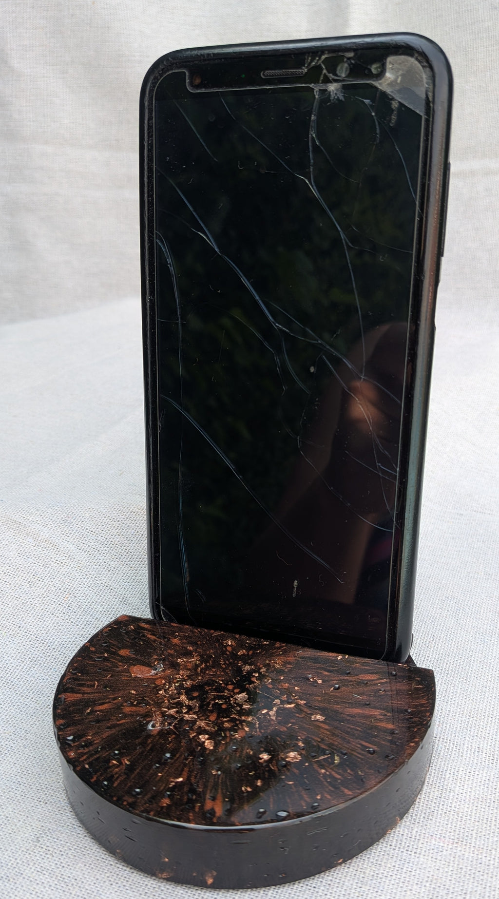 Smartphone resting in black copper resin phone stand – handmade dark aesthetic desk gift – EL-CreationS