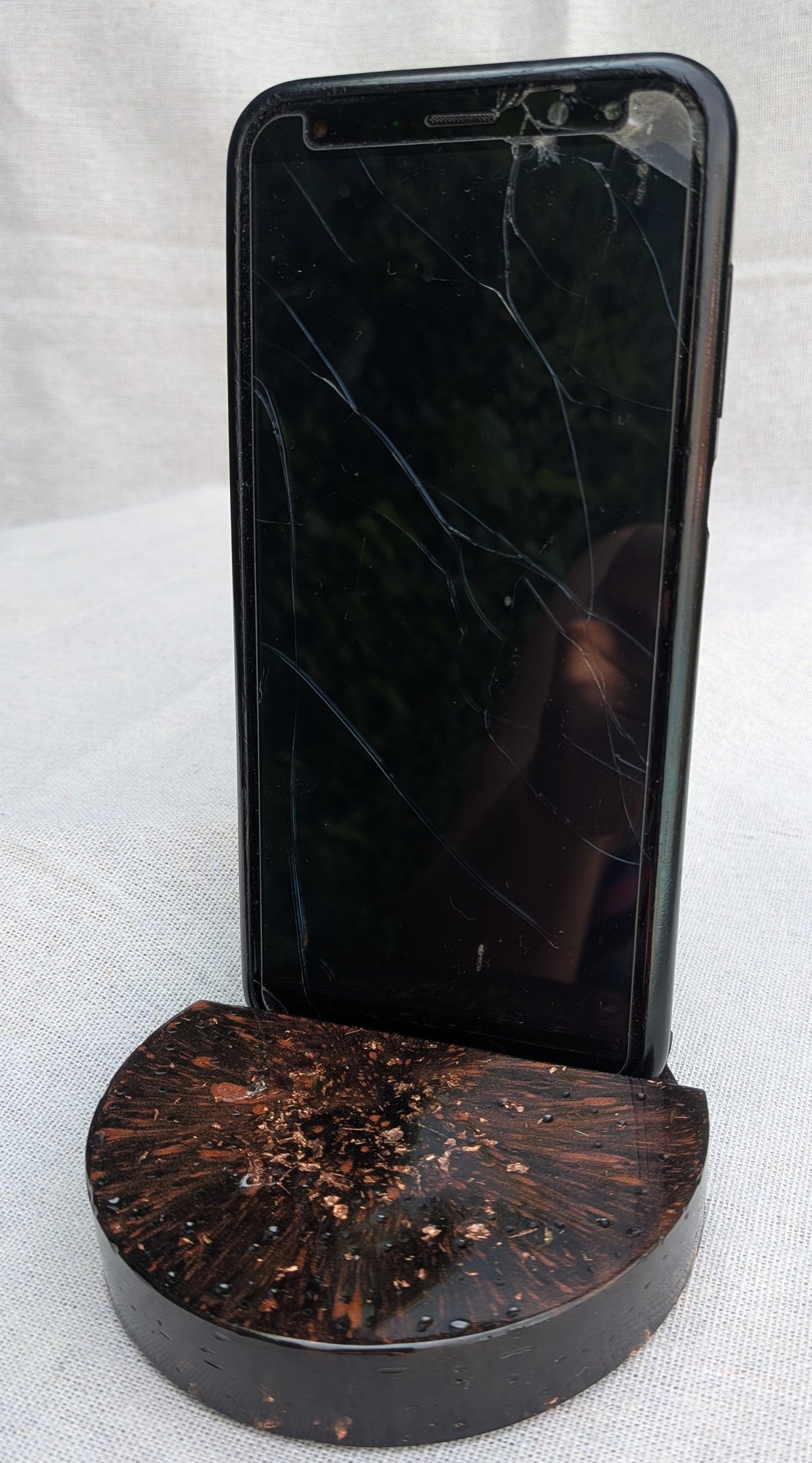 Smartphone resting in black copper resin phone stand – handmade dark aesthetic desk gift – EL-CreationS