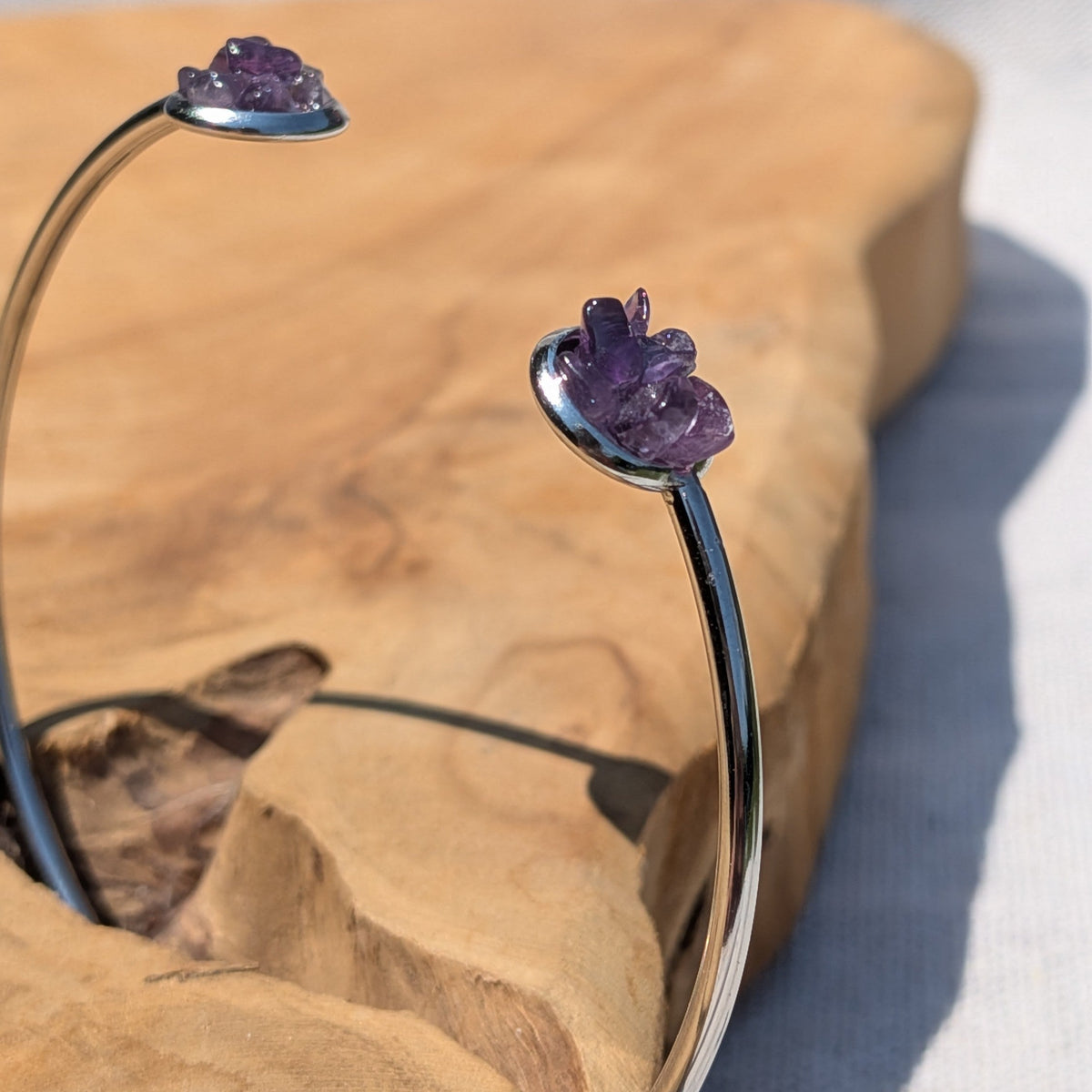 Open stainless steel cuff bracelet with two raw amethyst bezels flat lay – EL-Creations