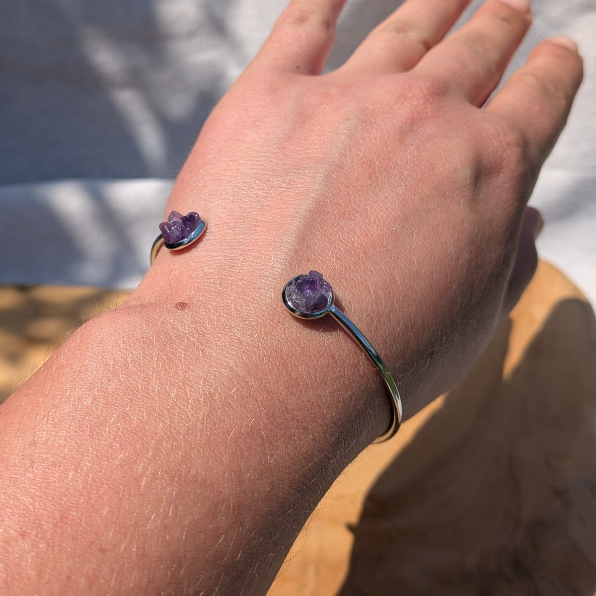Close-up of raw amethyst crystal set in stainless steel bezel on wrist – EL-Creations