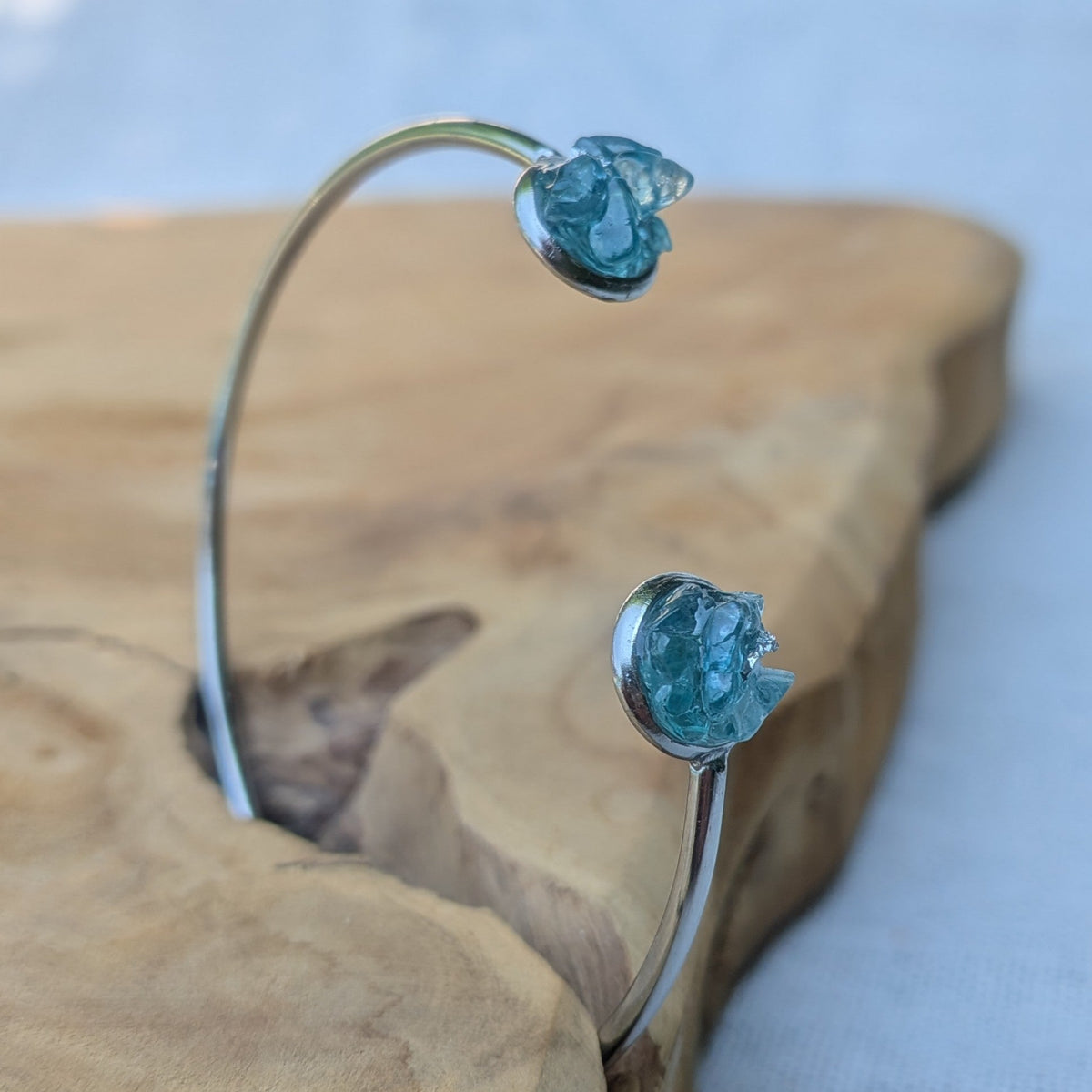 Handmade blue topaz resin cuff bracelet side view on wood – EL-Creations