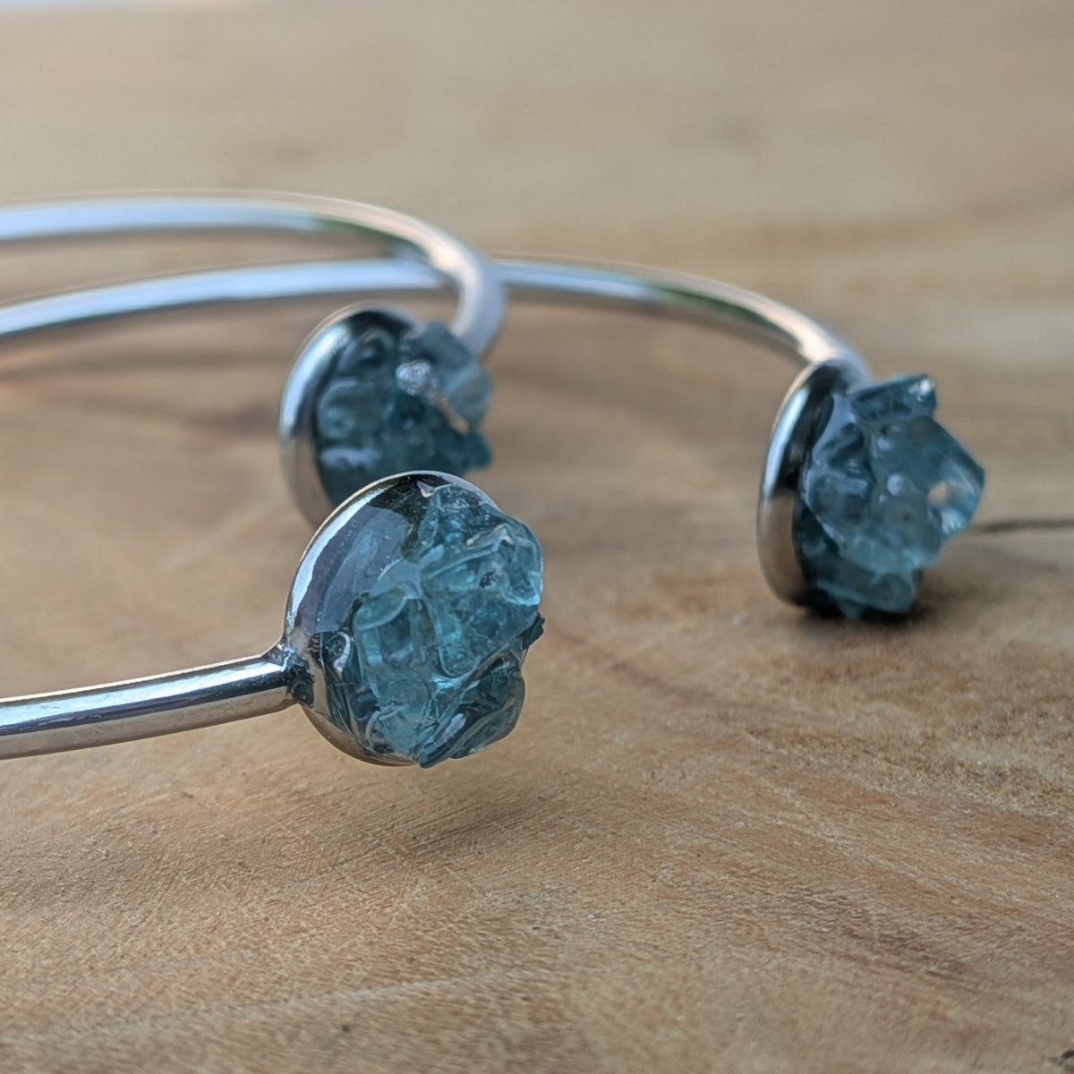 Three raw blue topaz stainless steel cuff bracelets detail on wood – EL-Creations