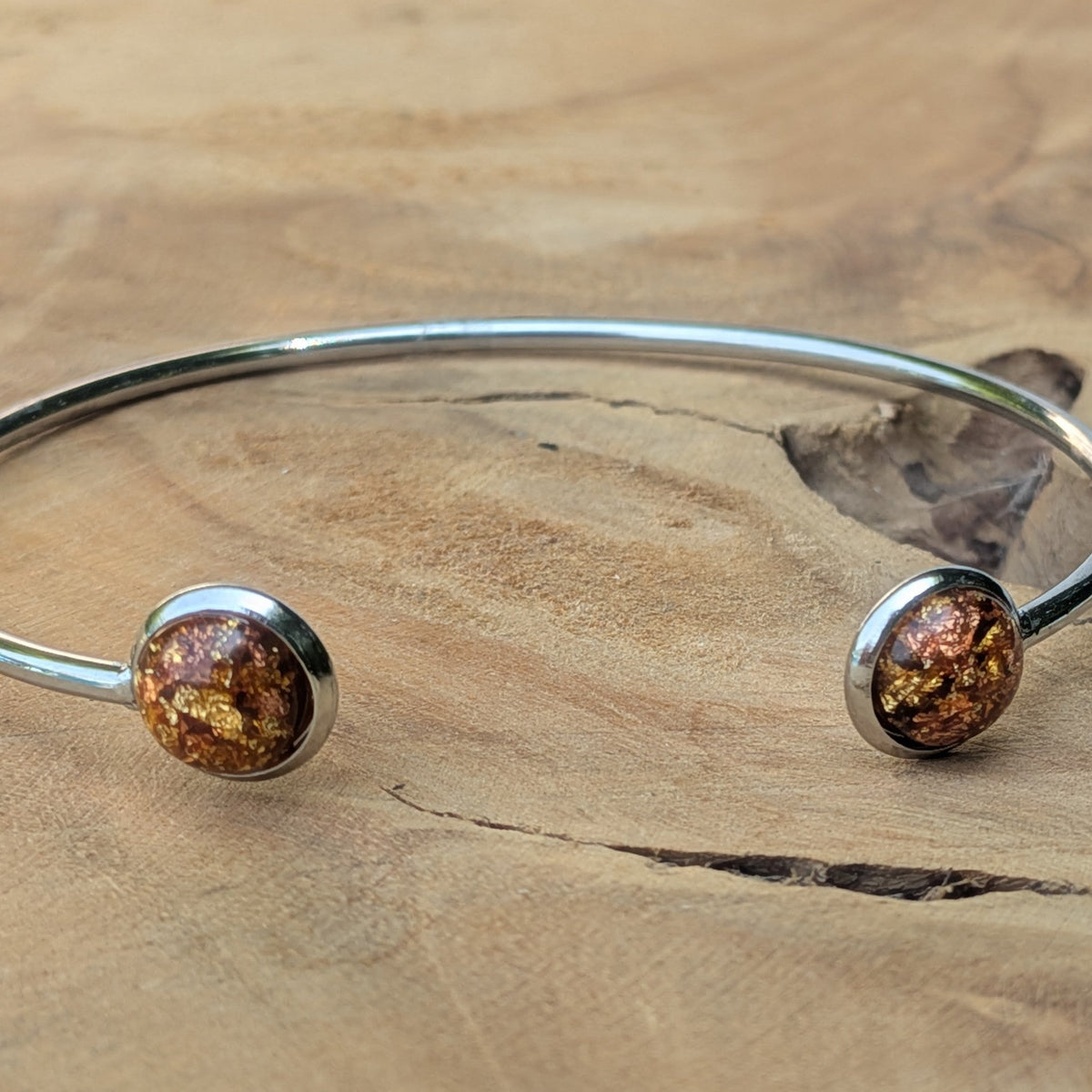 Close-up of amber gold resin cabochon in stainless steel bezel cuff bracelet – EL-Creations