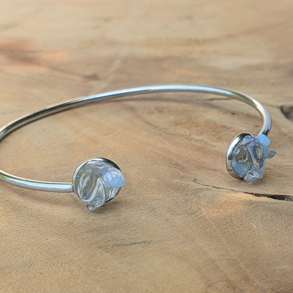 Moonstone crystal open cuff bracelet on wooden surface flat lay – EL-Creations
