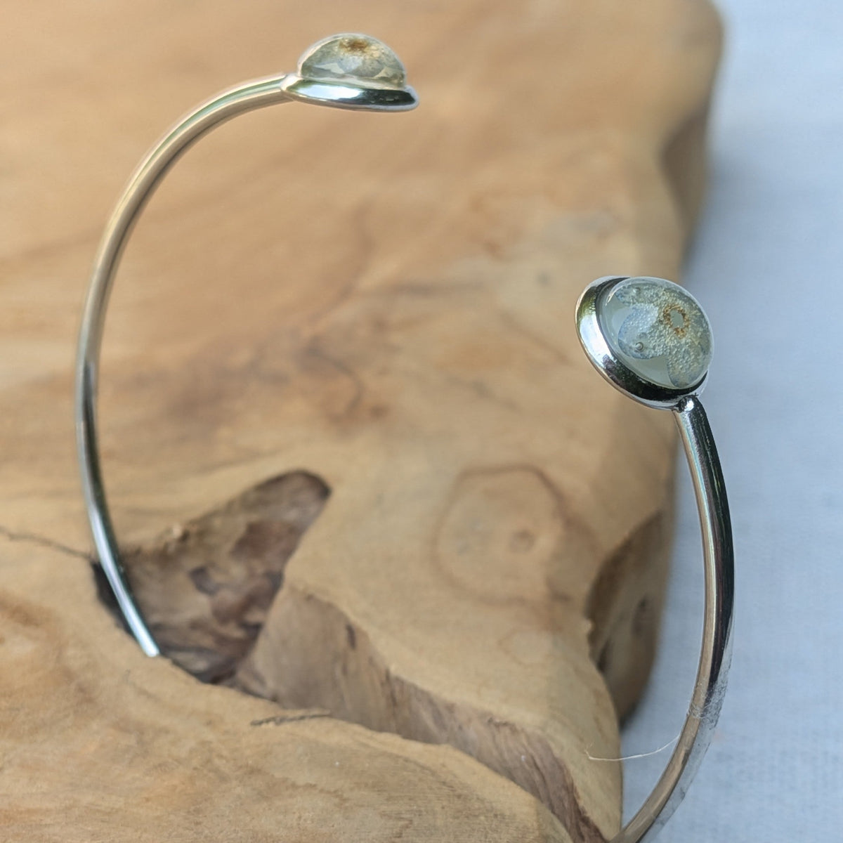Close-up of forget-me-not flower preserved in resin cabochon stainless steel bracelet – EL-Creations