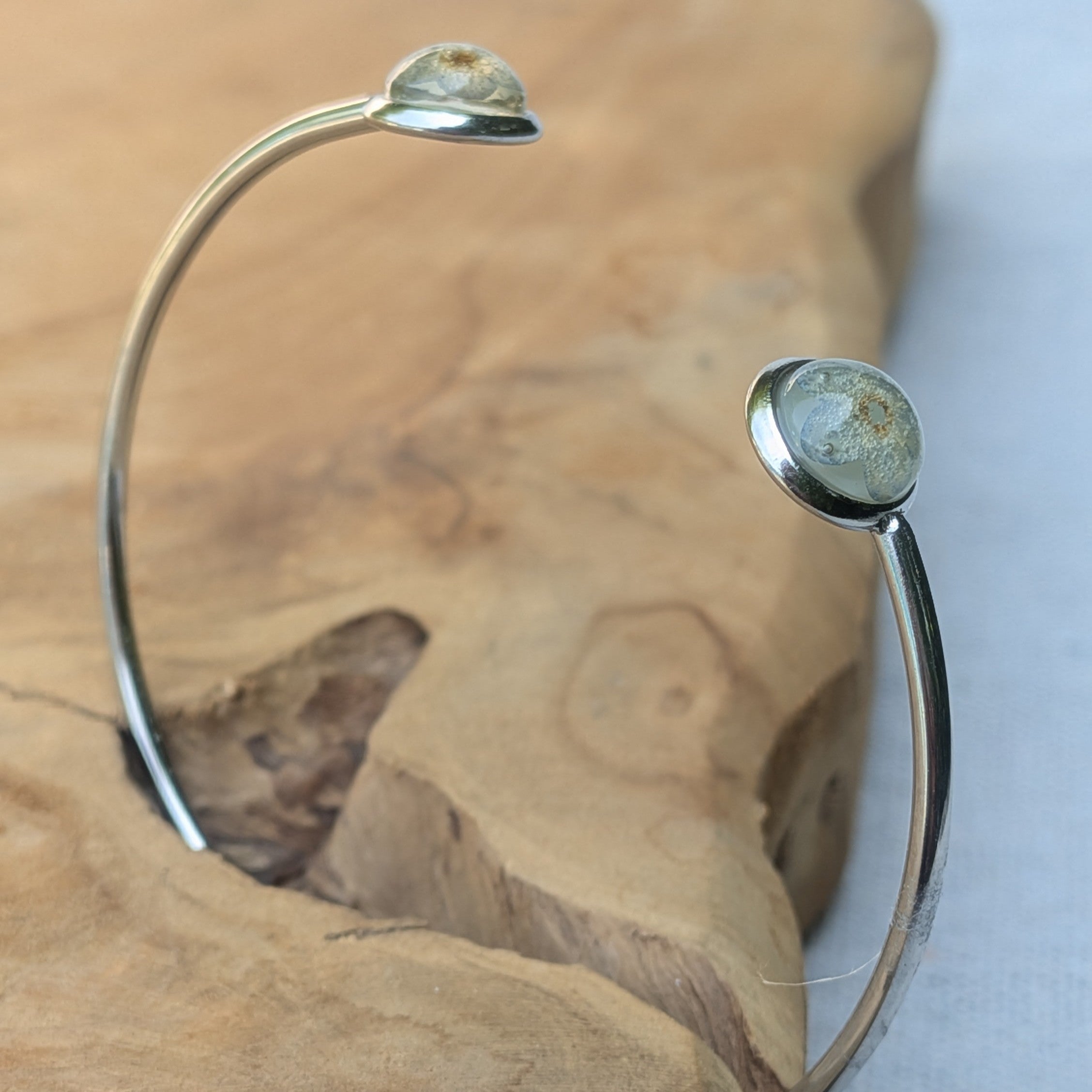 Close-up of forget-me-not flower preserved in resin cabochon stainless steel bracelet – EL-Creations