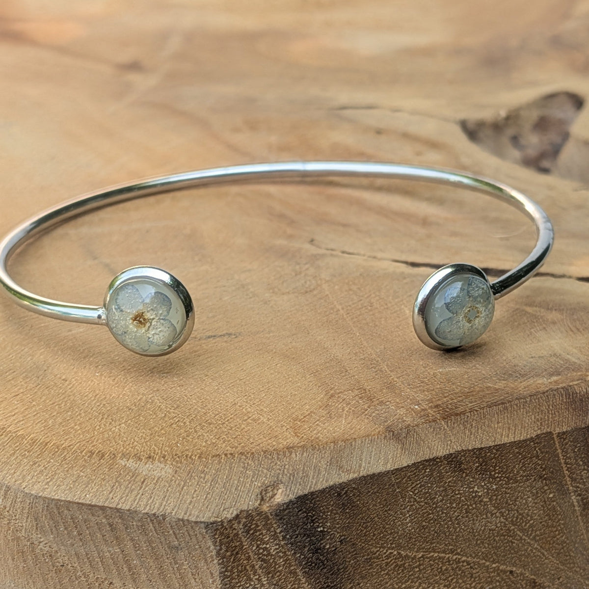 Forget-me-not resin cuff bracelet top view on wooden surface – EL-Creations