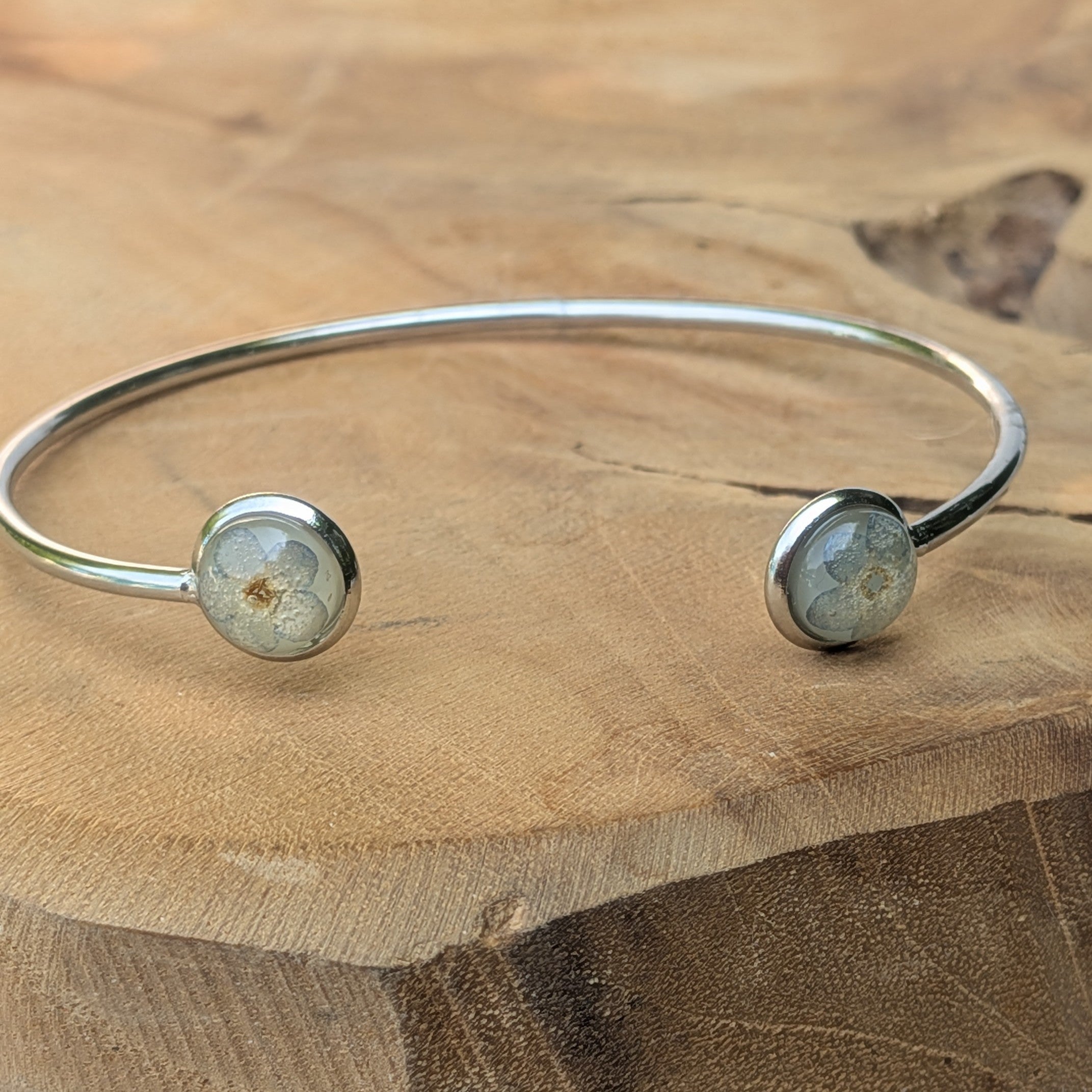 Forget-me-not resin cuff bracelet top view on wooden surface – EL-Creations