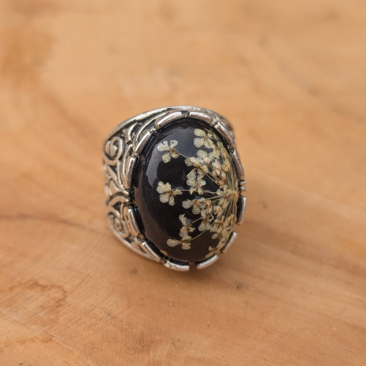Queen Anne's Lace resin ring antique silver filigree band angled view on wood – EL-Creations
