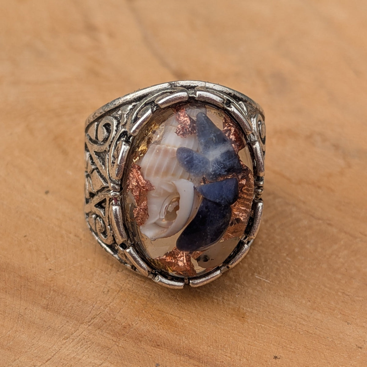 Adjustable baroque filigree ring back view showing open band and resin cabochon underside on wood – EL-Creations