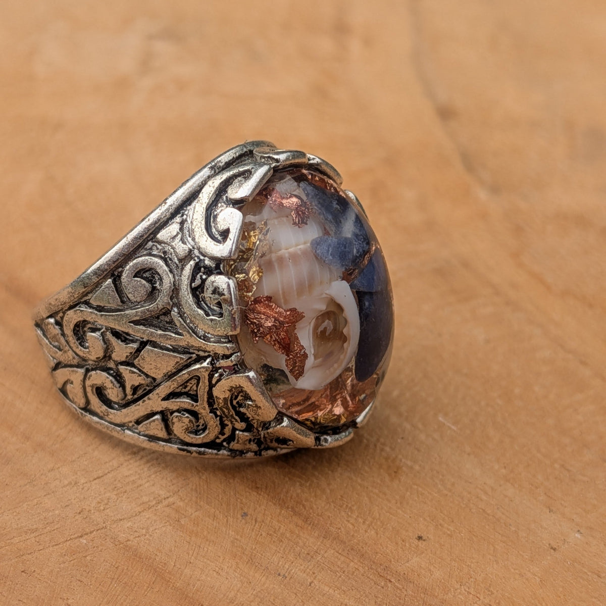 Sodalite copper shell resin statement ring front view showing full filigree scrollwork on wood – EL-Creations
