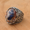 Oval resin ring with sodalite and copper flakes side profile showing baroque band detail on wood – EL-Creations