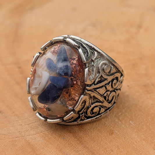 Oval resin ring with sodalite and copper flakes side profile showing baroque band detail on wood – EL-Creations