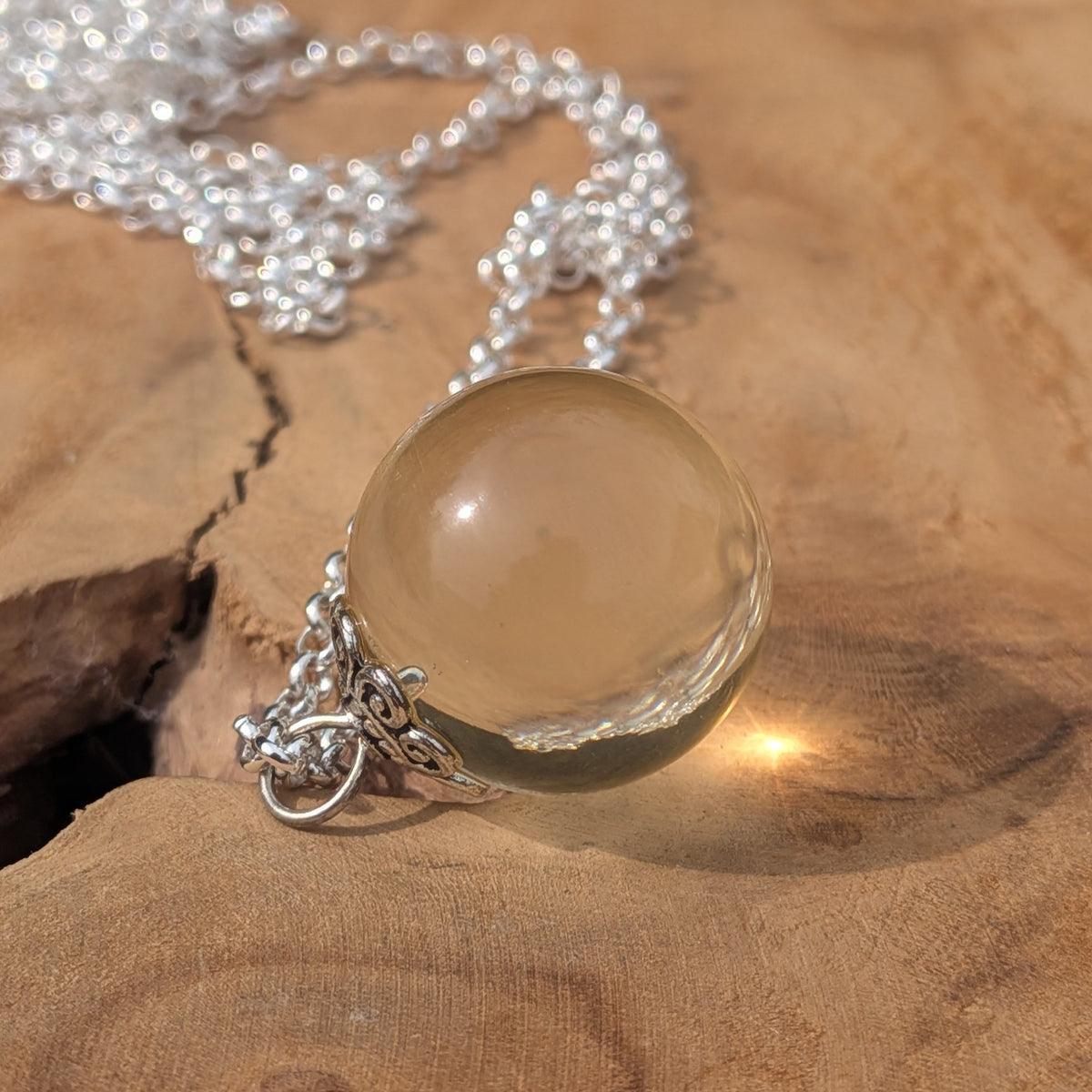 Transparent resin sphere pendant on hypoallergenic silver chain — handmade in Belgium