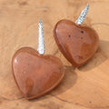 Handmade brown resin heart earrings 20mm diameter with hammered silver hooks side view on driftwood – EL-Creations
