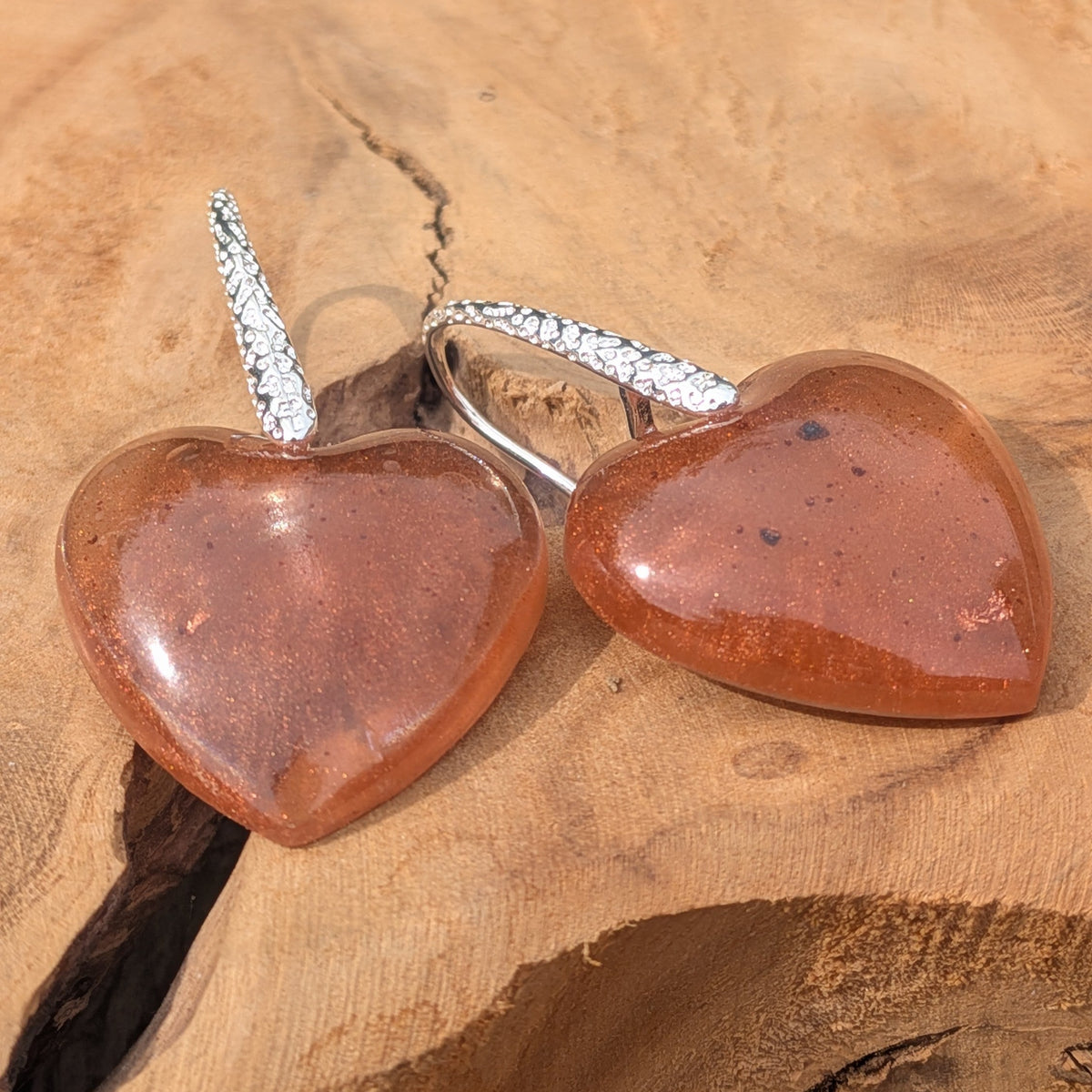 Oversized resin heart earrings 42mm total length warm brown copper flakes on driftwood top view – EL-Creations