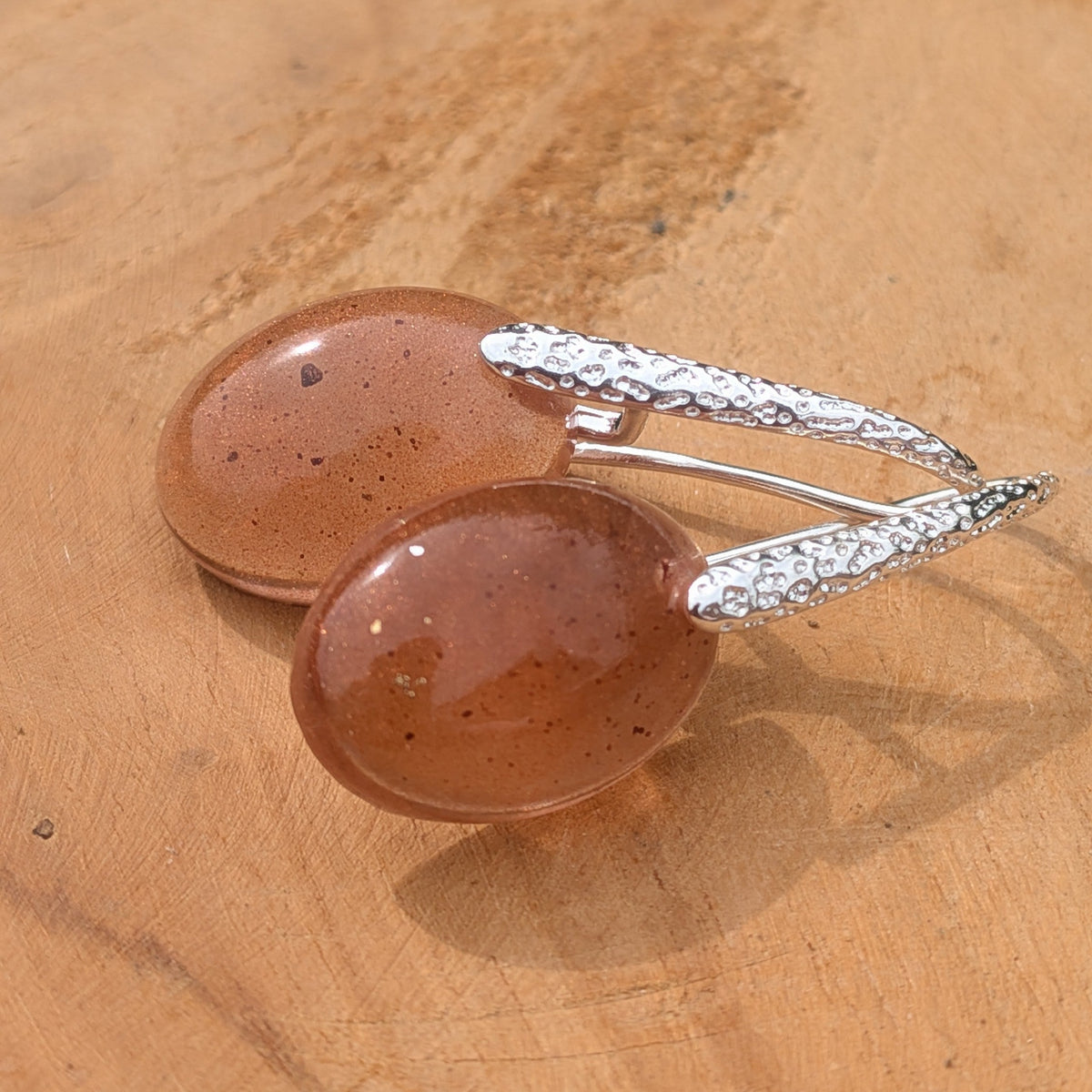 Minimalist brown resin oval drop earrings with textured silver hooks on wooden surface front view – EL-Creations