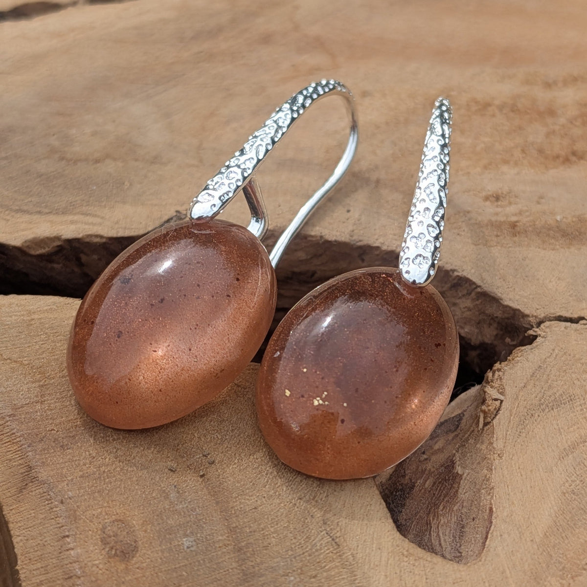 Brown resin oval earrings with copper flakes close-up showing translucent depth on driftwood – EL-Creations