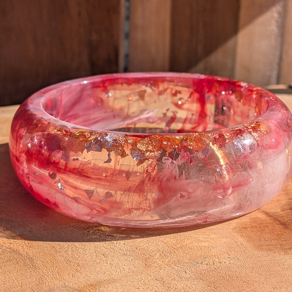Chunky dome resin bangle rose and crimson pigment swirls top view showing inner diameter 67mm on wood – EL-Creations