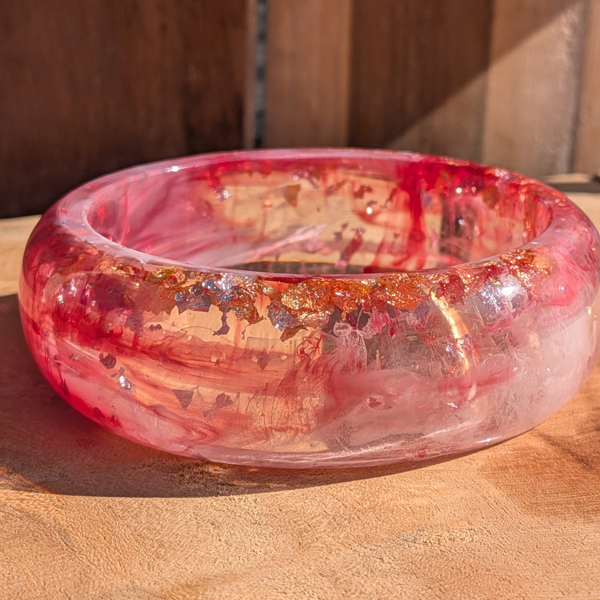 Chunky dome resin bangle rose and crimson pigment swirls top view showing inner diameter 67mm on wood – EL-Creations