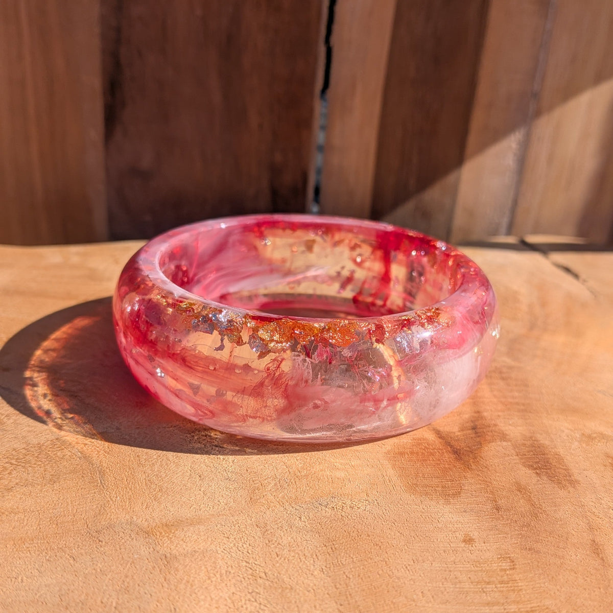 Pink red resin statement bangle worn on wrist close-up showing dome profile and high-gloss surface – EL-Creations