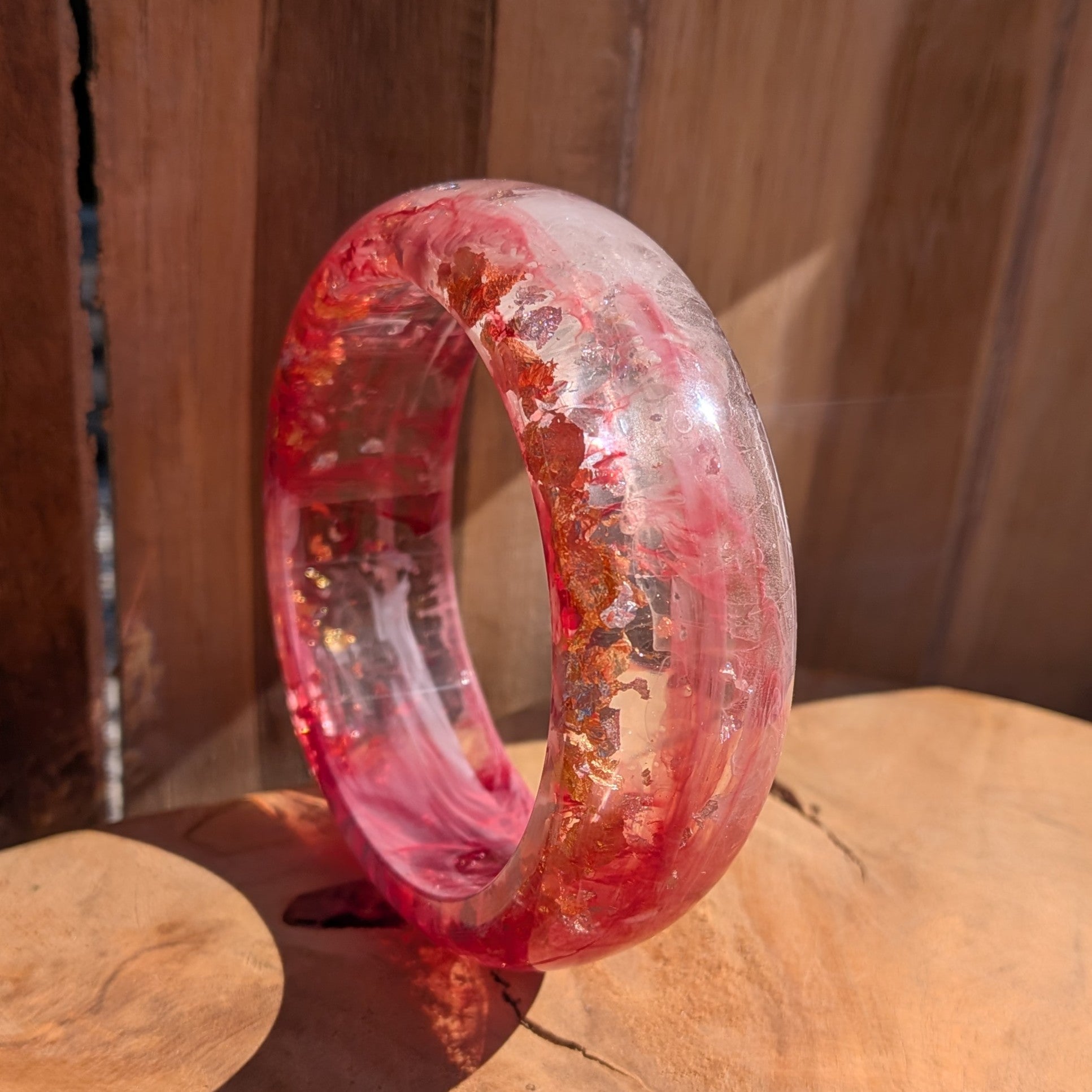 Bold pink resin dome bangle close-up showing gold copper silver flake detail and polished surface on wood – EL-Creations