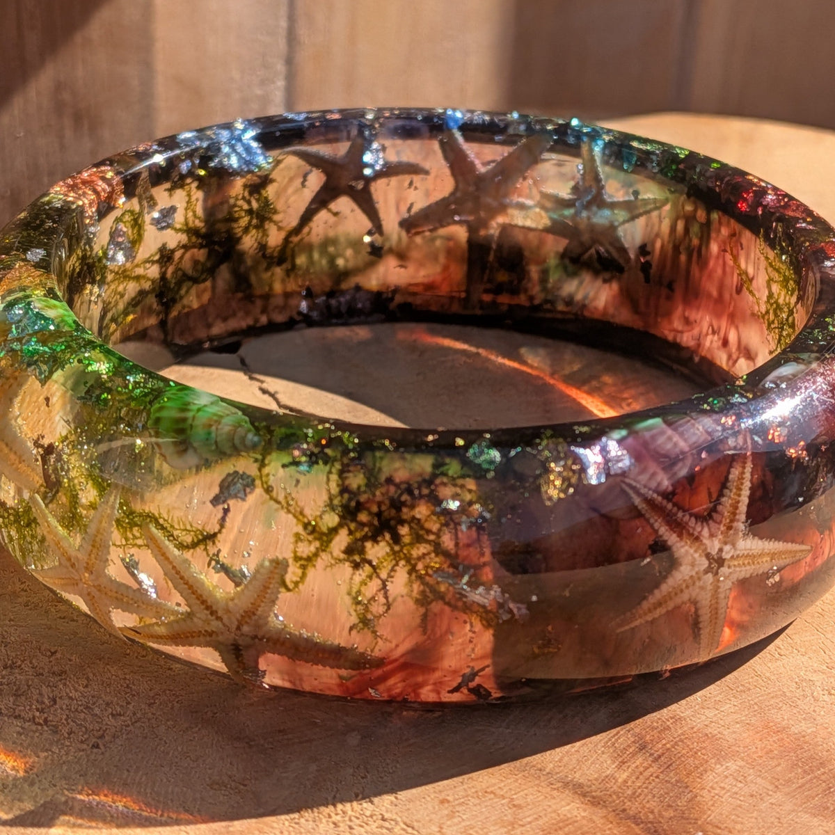 Ocean resin slip-on bangle flat lay showing full composition of starfish seashells sea moss and metallic flakes – EL-Creations
