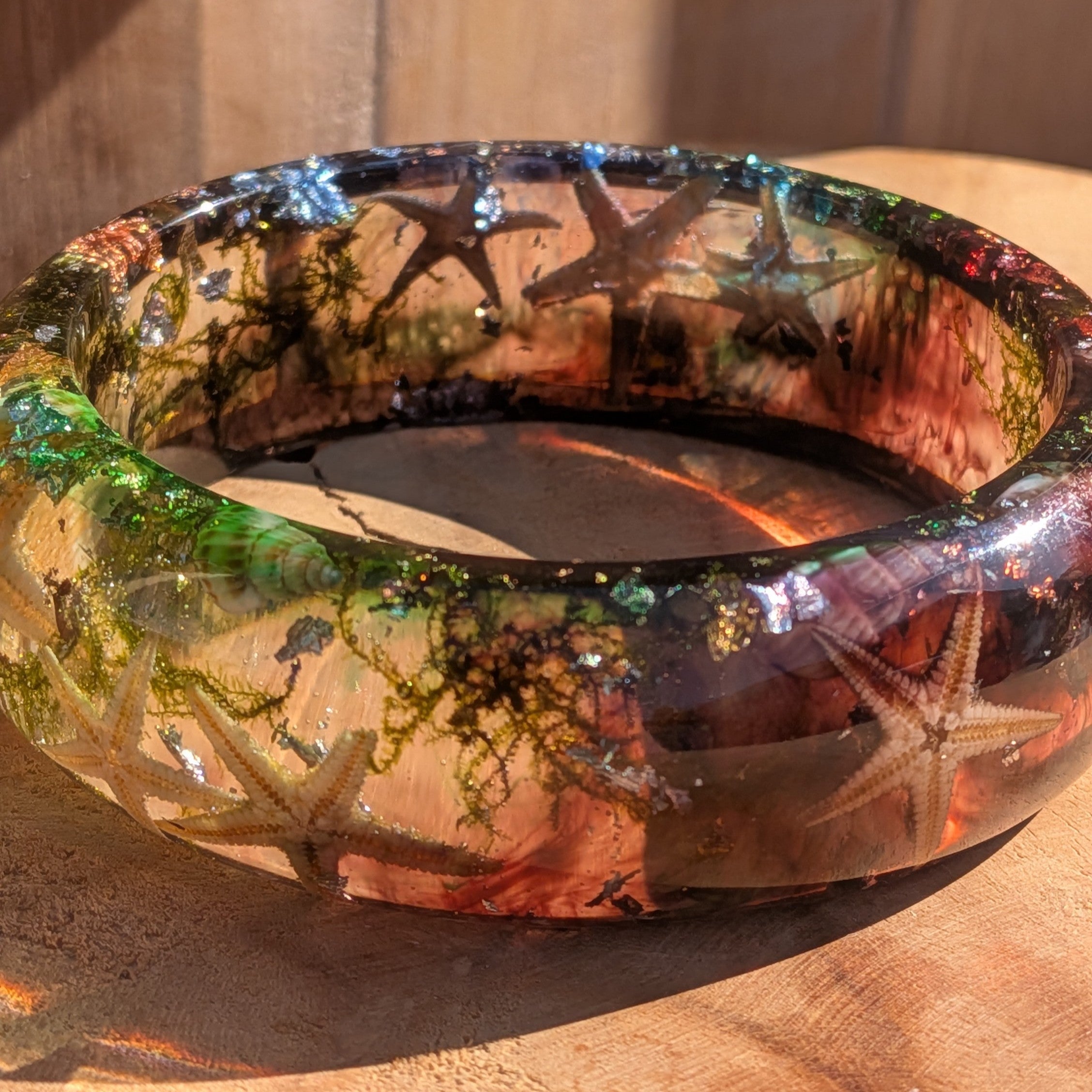 Ocean resin slip-on bangle flat lay showing full composition of starfish seashells sea moss and metallic flakes – EL-Creations